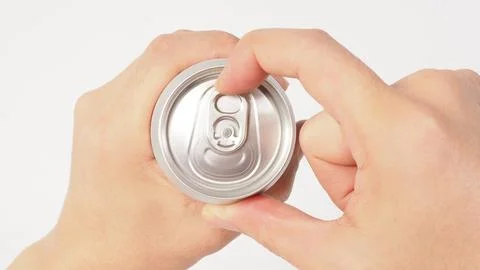 A close up of two hands opening a silver aluminum can.viewed from the top. Foto stock
