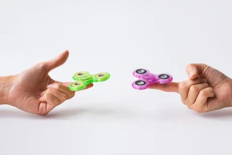 Close up of two hands playing with fidget spinners Fotos Stock