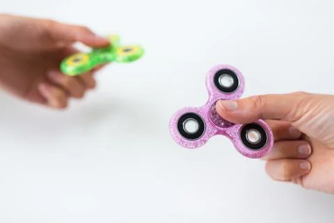 Close up of two hands playing with fidget spinners Stock Photos