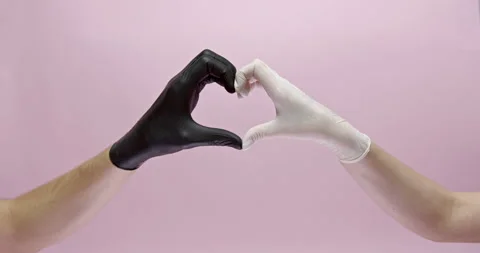Close up of two hands in white and black rubber gloves making heart shape over Stock Footage 146396779