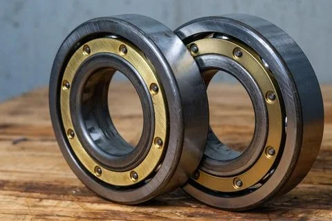 Close Up Two Heavy Industrial Ball Bearings On Workbench. Stock Photos