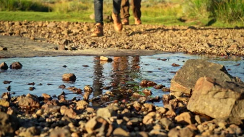 Close up of two hikers legs walking towards a locked off camera Stock Footage 254789996