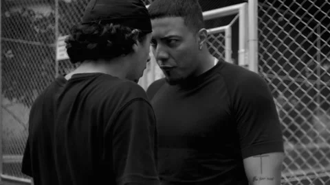 Close-up of two Hispanic men in intense argument, standing face to face with ang Видео 320056725