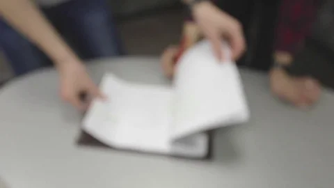 Close-up two human writing something on the note paper on the table Stock Footage 74083087