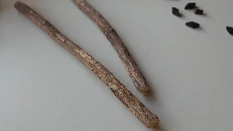 Close-up of two liquorice candy sticks on white surface with minimal food Stock Footage 333667455