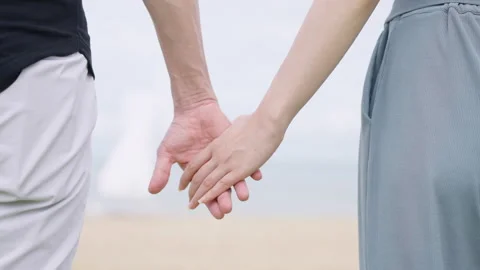 Close-up two lovers couple joining hands together against the sea beach Stock Footage 159845447