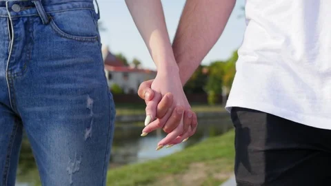 Close up of two lovers joining hands. Detail silhouette of man and woman holding Stock Footage 116666966