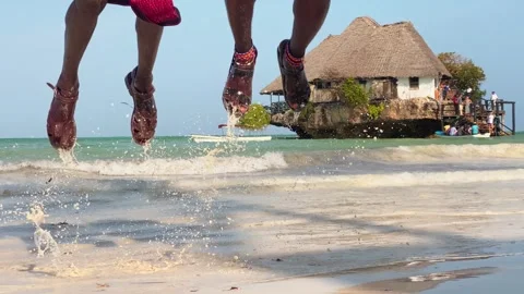 Close up two Maasai man performing traditional jump on Zanzibar beach with .. Stock-Footage 329540475