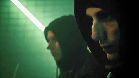 Close up two male hacker in a hood works on a computer in a dark office room. in Stock Footage 106353095
