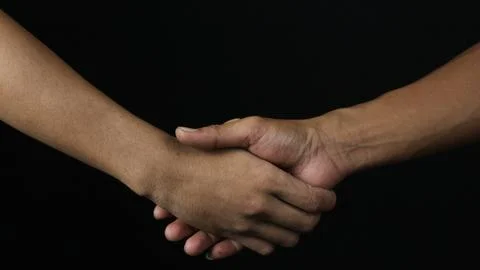 Close up two man shaking hand as agreement on black background. Stock Photos