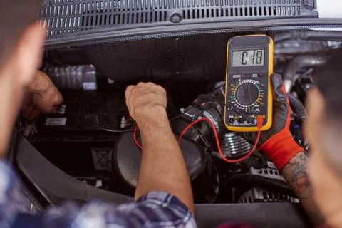 Close up of two mechanics checking the pressure in the engine. Stock Photos
