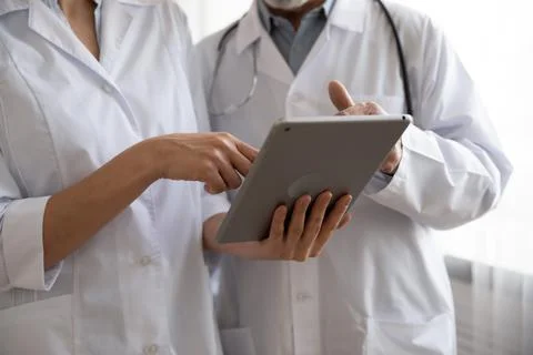 Close up two medical workers using digital computer tablet. 스톡 사진