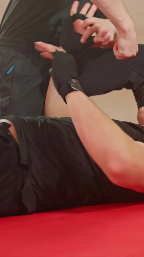 Close up of two men in black athletic wear engaging physically with grappling Stock Footage 343089097