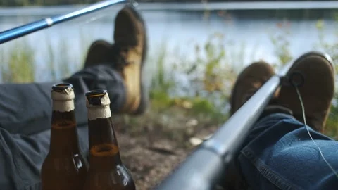 Close-up two men drinking beer on a fishing trip Stock Footage 236335726