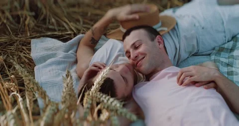 Close up two men gay lying on field at the wheat smiling looking lovely at each Stock Footage 200956761