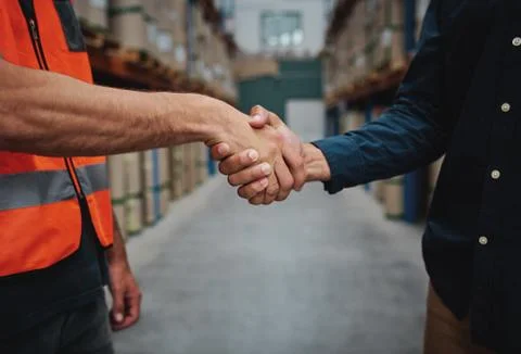 Close-up of two men handshake while concluding agreement about container rent Stock Photos