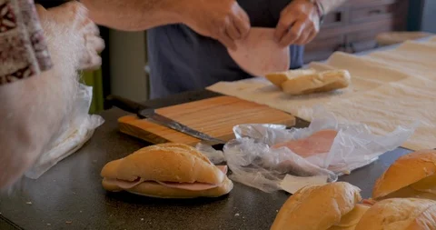 Close up of two men making a lot of ham and cheese sandwiches together Stock Footage 95127614