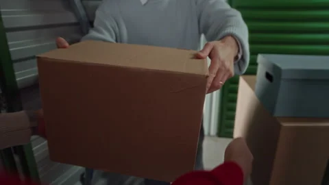 Close Up of Two Men Placing Cardboard Boxes inside Storage Unit 스톡 동영상 327783815