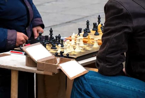 Close-up of two men playing chess on the street due corana pandemic Stock Photos