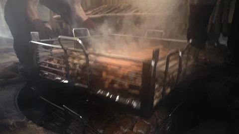 Close up two men removing tray from hangi Vídeos de archivo 107922093