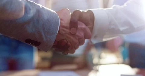 Close up of two men shaking hands. African American man holds out his hand to 動画素材 140286161