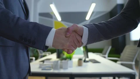 Close-up of two men in suits shaking hands in the office. Stock Footage 233993864