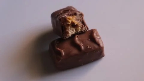 Close-up of two milk chocolate bars with caramel and nougat filling 스톡 동영상 329615562