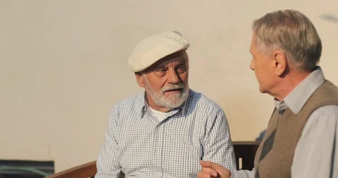 Close up of the two old Caucasian retired men neighbors talking while sitting Stock Footage 99429932