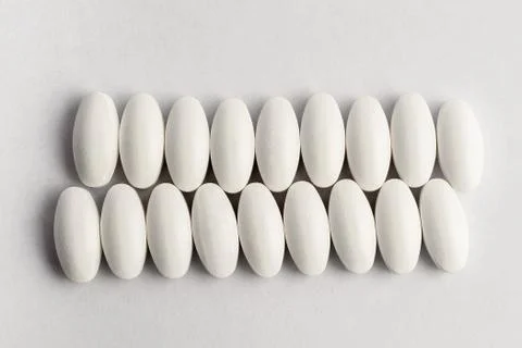 Close up of two parallel lines on white pills on white background Stock Photos