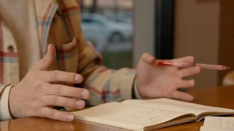 Close-up of two people discussing notes and documents on a cafe table Fotos de archivo
