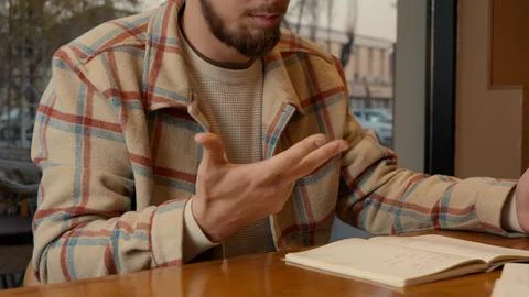 Close-up of two people discussing notes and documents on a cafe table Stock Photos