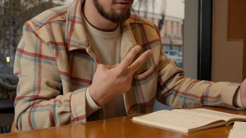 Close-up of two people discussing notes and documents on a cafe table Stock Photos