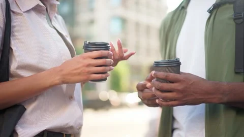 Close-up of two people holding coffee cups during a conversation. Female in Stock Footage 311810454