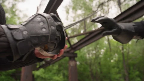 Close up two people in medieval armor examining metal fish shaped weapon Stock Footage 345084577