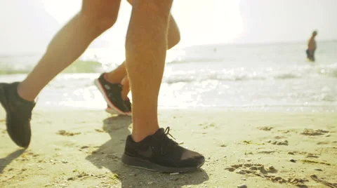 Close up of two people running on the beach Stock Footage 68857340