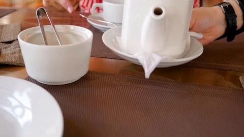 Close-up for two people a waiter on table brings hot coffee and tea. Attendants Stock Footage 108993433