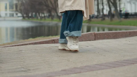 Close up of two people walking side by side on paved path in outdoor park with Vídeo Stock 344876353