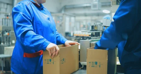 Close-up of two people who pack products of liquid soap in white bottles in Stock Footage 90154525