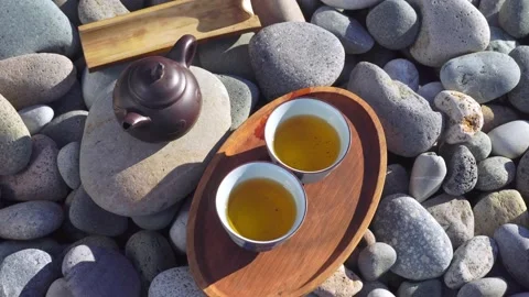 Close-up of two poured cups of tea on a wooden tray, brown teapot, Stock Footage 168528038