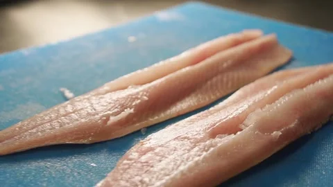 Close up of two raw white fish fillets on cutting board with a knife. Stock Footage 204818897