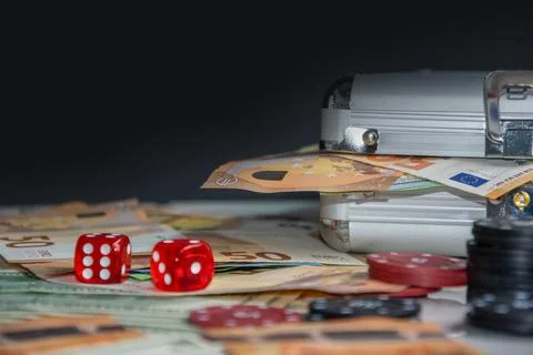 Close-up of two red dice on a table surrounded by euro bills, casino chips,.. Stock Photos