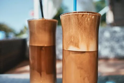 Close up of two refreshing iced coffees with thick foam in tall glasses 스톡 사진