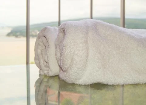 Close-up of two rolls of white terry towels lying on a transparent glass tabl Foto stock