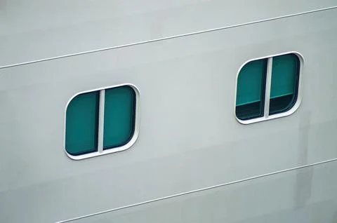Close up of two rounded rectangular windows with green tinted glass on the .. 库存照片