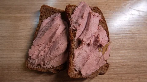 Close-up of two slices of dark rye bread generously Stock Footage 328580133