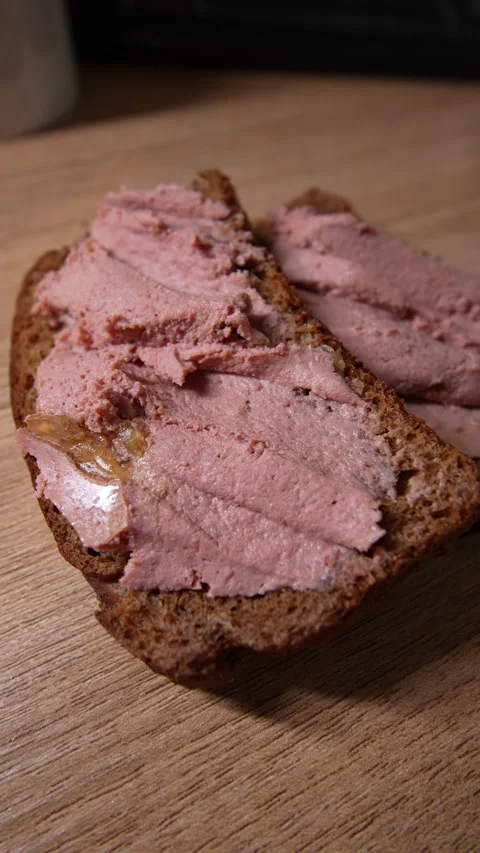 Close-up of two slices of dark rye bread generously Stock Footage 328580137