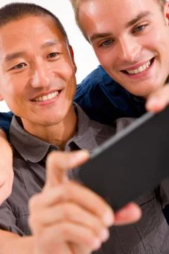 Close-up of two smiling friends taking self portrait with cell phone Stock Photos