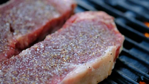 Close up of two steaks right after they are put on the grill Stock Footage 140066279