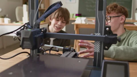 Close up of Two Students Setting Up Equipment and Discussing Printing Process Stock Footage 335691708
