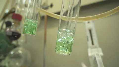 Close-up two test tubes boiling over fire against the background of laboratory Stock Footage 153863542